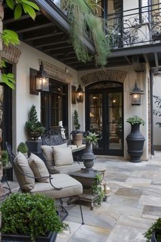 an outdoor living area with couches, chairs and potted plants on the patio