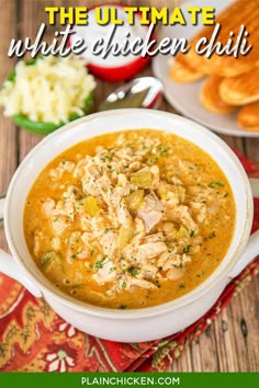 the ultimate white chicken chili in a bowl with bread and other food on the side