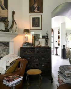 a living room filled with furniture and pictures on the wall above it's fireplace