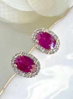 "Natural Ruby (1.10ct) Diamond Halo Solid 14k Yellow Gold Stud Earrings, New* These beautiful earrings are made of solid 14k yellow gold and features 2pcs, genuine, natural, oval, ruby gemstones measuring 4 mmx 5.75mm (1.10ct). These earrings have a classic design with a 24pc diamond halo of single-cut gemstones (I, VS2, 0.10ctw). These earrings are studs with pushbacks for closures, they measure 0.33\"x 0.22\" and weigh 1.95 grams. The gemstones are natural and have inclusions, the color satura Luxury Oval Ruby Earrings, Oval Red Diamond Earrings For Anniversary, Red Oval Diamond Earrings For Anniversary, Oval Ruby Earrings With Halo Design, Red Oval Halo Design Earrings, Hallmarked Oval Diamond Earrings, Yellow Gold Oval Diamond Earrings With Gemstone, Oval Ruby Earrings For Anniversary, Aaa Quality Oval Diamond Earrings