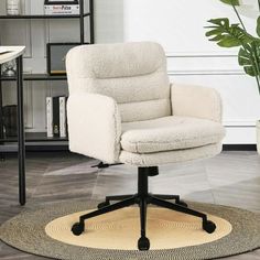 a white office chair sitting on top of a rug in front of a book shelf