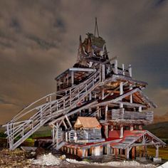 a very tall wooden structure with stairs on it's sides and a sky background