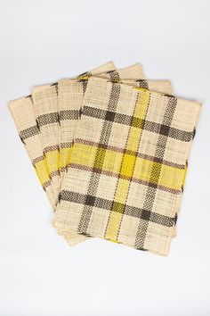 three yellow and black plaid napkins sitting on top of each other