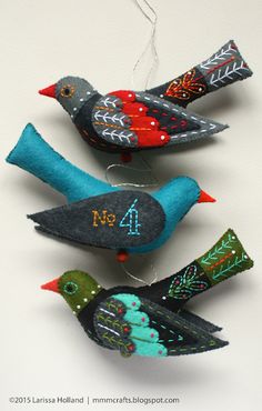 three felt birds with numbers on them are hanging from strings and decorated with beads ornament