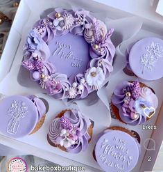 cupcakes decorated with purple icing and flowers in a box for a mother's day