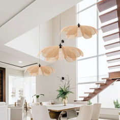 a dining room table with chairs and lights hanging from the ceiling