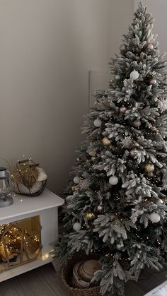 a white christmas tree with gold and silver ornaments