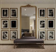 a bed sitting under a large mirror next to a wall with pictures on the walls