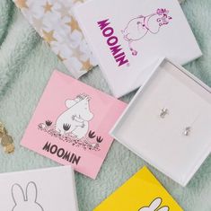 four different colored cards are laying on a blanket with the word moomi written in them