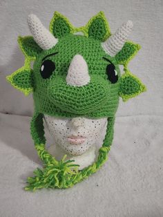 a crocheted green hat with horns on it