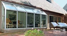 an outside patio with chairs and tables next to a house that has large sliding glass doors