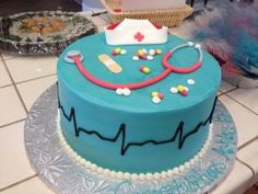 a blue cake with a stethoscope and medical symbols on it sitting on top of a table