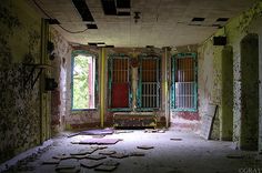 an old run down building with broken windows and peeling paint on the walls, in disrepair