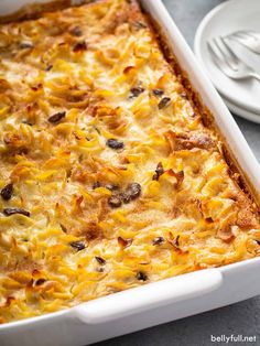 a casserole dish with cheese and mushrooms in it next to a white plate