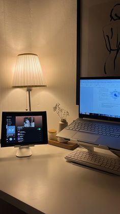 a laptop computer sitting on top of a desk next to a monitor