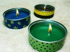 two tins with candles in them sitting on a white carpet next to each other