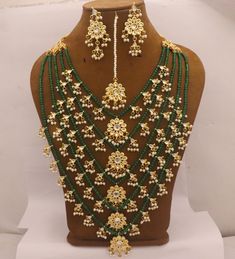 Kundan 5 Layers Long Rani Haar Necklace Earrings Tika Jewelry Set, Green Beads Minakari Work Pearls Jewelry, Bridal Rani Haar Wedding Set Metal = Gold Plated Occasion = Wedding ,Party Wear, Bridal Color = Green and Yellow Size = Necklace Length = 35 CM Earrings/Studs = 7 CM Tika = 10 CM Please update shipping profile for Express shipping (delivery in 3 to 7 working days) 100% Satisfaction Guarantee: 1 Year Warranty, Long Lasting Plating, High-Quality Stones Occasion: Perfect choice for any India Gold Jewelry Sets With Dangling Beads For Wedding, Temple Jewelry Sets With Dangling Beads For Wedding, Tilla Beaded Necklaces With Round Beads For Wedding, Chandbali Kundan Necklace With Dangling Beads For Wedding, Kundan Jewelry Sets With Round Beads For Wedding, Kundan Jewelry Sets For Wedding, Traditional Beaded Necklaces With Dangling Beads For Weddings, Gold Bridal Necklace With Dangling Beads For Wedding, Traditional Wedding Beaded Necklaces With Dangling Beads