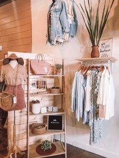 a clothing store with clothes and handbags hanging on the wall next to shelves filled with items