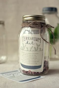 a jar filled with lots of dirt sitting on top of a table