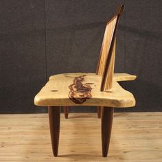 a wooden chair sitting on top of a hard wood floor next to a black wall