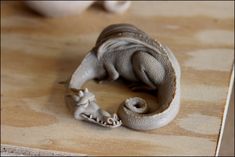 a small elephant figurine sitting on top of a wooden table next to an egg