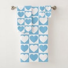 two blue and white hearts are hanging on a towel rack in front of a wall