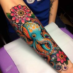 an octopus and flower tattoo on the arm