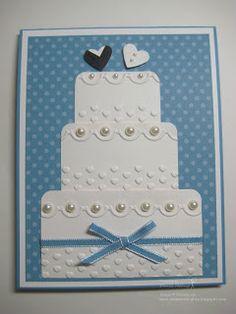 a wedding card with two tiered cake on it and blue ribbon around the edge