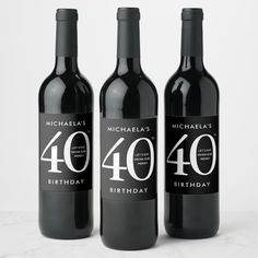 three bottles of wine with the number forty and forty birthday written on them, sitting next to each other