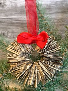 a christmas ornament made out of newspaper strips with a red bow hanging from it