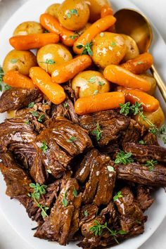 a white plate topped with meat and carrots