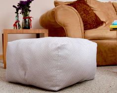 a living room with a couch, chair and footstool on the floor in front of a coffee table