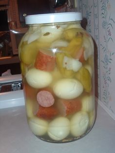 a jar filled with pickles and potatoes on top of a counter