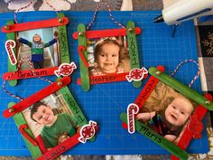 four frames with children's pictures hanging from them on a blue mat next to scissors