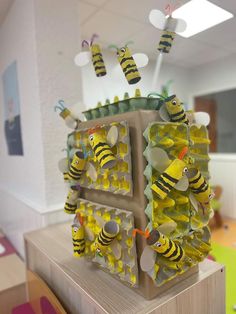 a group of bees that are sitting on top of a box in the shape of a beehive