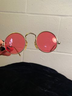 "These sunnies are a safe way to see the world through rose-colored lenses! Perfect fit for a woman or smaller man. Due to age, they have a few flaws: the arms are a bit bent out of shape, but this doesn't have much impact on the wear. The lenses are also mostly scratched, but again, this has no little to no effect on the wear. Great for photoshoots or collecting True vintage, not a reproduction Each lens measures 1 7/8\" in diameter." Vintage Sunglasses With Mirrored Glass Lenses, Pink Sunglasses With Mirrored Lenses And Round Frame, Pink Round Frame Sunglasses With Mirrored Lenses, Red Retro Sunglasses With Gradient Lenses, Retro Red Sunglasses With Gradient Lenses, Vintage Round Sunglasses With Uv Protection, Vintage Red Sunglasses With Mirrored Lenses, Vintage Round Sunglasses With Polarized Lenses, Vintage Round Sunglasses With Mirrored Lenses