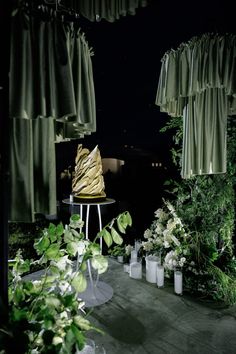 an outdoor area with green curtains and plants