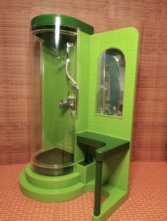 a green bathroom with a stand up shower next to a stool and mirror on the wall