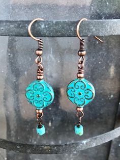 Light weight turquoise patina copper patterned drops swing from hand crafted copper findings.  At the bottom of each swings a Czech glass bead to catch the light.  Elegant and Bohemian, these dangles move from beach to boardroom effortlessly. The copper components are oxidized to an delicious red/brown patina. Hand crafted in the Wild Fire Studio in the Texas Hill country. Free domestic shipping. Bohemian Copper Earrings With Patina, Adjustable Bohemian Patina Earrings, Handmade Turquoise Earrings With Copper Wire, Turquoise Patina Dangle Earrings, Turquoise Dangle Earrings With Patina, Bohemian Blue Copper Earrings, Bohemian Blue Earrings, Turquoise Beaded Copper Earrings, Turquoise Patina Copper Jewelry