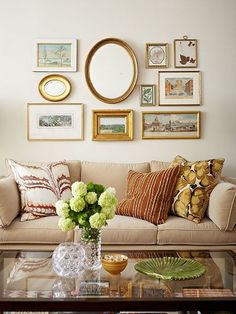 a living room filled with lots of furniture and pictures on the wall above it's coffee table