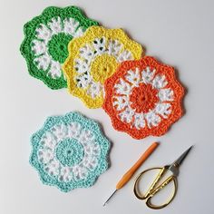 crocheted doily with scissors and yarn on white table top next to it