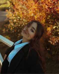 a woman in a suit and tie leaning against a rail