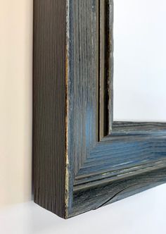 a wooden frame hanging on the wall with a blue stripe in it's center