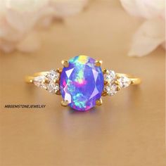 an opal and diamond ring on a table