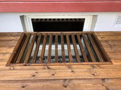 a wooden floor with a vent on the side and a window in the middle that is open