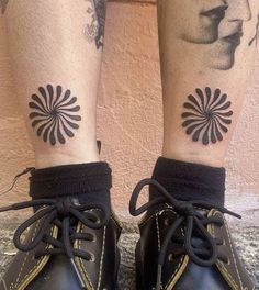 a woman's legs with tattoos and boots on her feet, both wearing black lace - up shoes