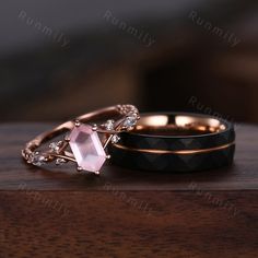 two wedding rings with diamonds on them sitting on a wooden table next to each other