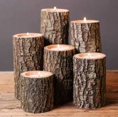 four wooden logs are stacked on top of each other, with one candle in the middle