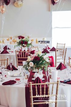 the tables are set with red and white linens, gold chairs, and balloons