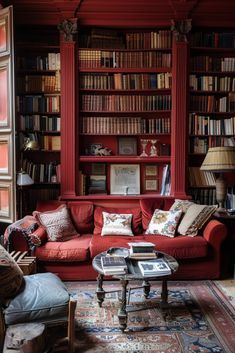 a living room filled with lots of red furniture and bookshelves full of books